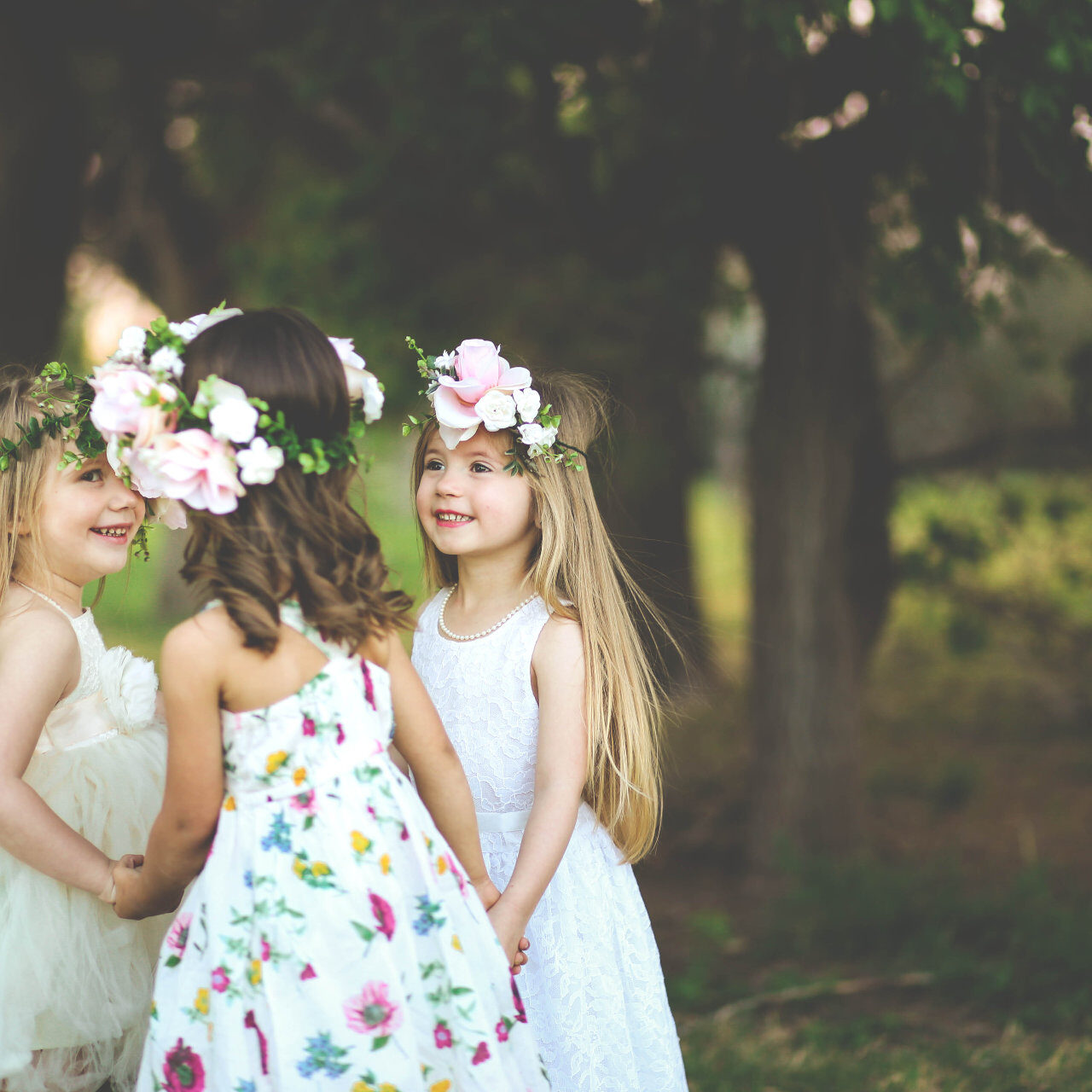 Three adorable spring girls play together in a garden